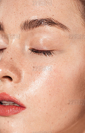 close up of young woman with eyes closed, coral lips and wet skin