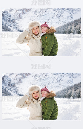 Happy mother and child outdoors in front of snowy mountains