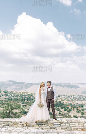 Wedding couple in the mountains at sunset in Cyprus. Beautiful panoramic view and the happy couple.