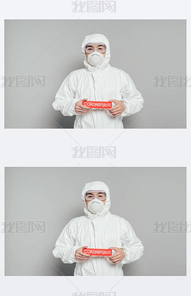 asian epidemiologist in hazmat suit and respirator mask holding warning card with coronirus inscri