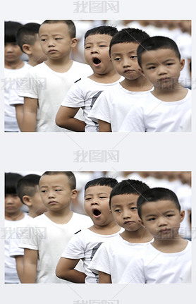 A young student yawns as he and other students attend a flag-raising ceremony of a new semester at a