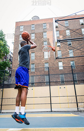 Afro-american basketball player training on a court in New York - Sportive man playing basket outdoo