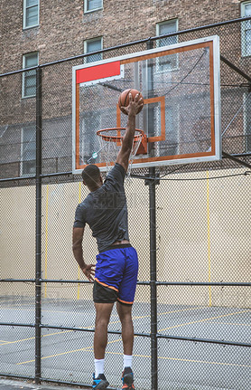 Afro-american basketball player training on a court in New York - Sportive man playing basket outdoo