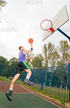 Young men playing street basketball at court playground