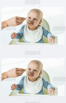 Mother with spoon feeding cute baby boy on feeding chair on white background