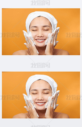 Happy young Asian woman applying face cream while wearing a towel and touching her face. Isolated on