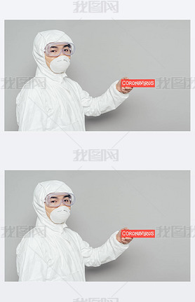 asian epidemiologist in hazmat suit and respirator mask holding warning card with coronirus inscri