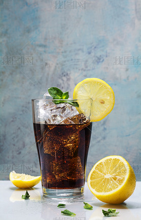 glass of cola or coke with ice cubes, lemon slices and peppermin