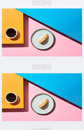 top view of fresh nigiri with shrimp near soy sauce on blue, pink, orange background