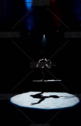 silhouette of aerial acrobat performing on rope in circus 