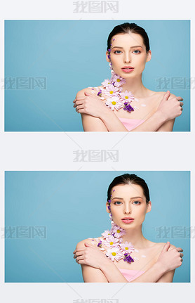 attractive woman with flowers and crossed arms isolated on blue 