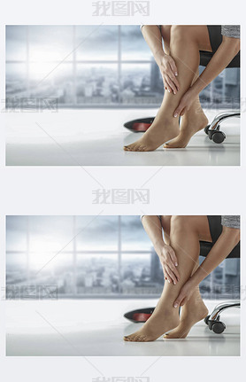 Tired woman`s legs. Woman sitting on a chair and  massaging tired and sore legs. Blurred urban backg