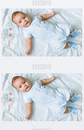 Portrait of a pretty little baby , lying on a light blanke