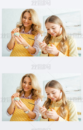 selective focus of happy daughter and mother painting easter eggs with paintbrushes 