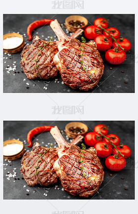 grilled beef steaks - tomahawk with tomatoes and red pepper on a stone background