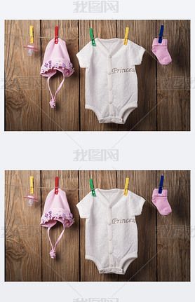 Baby clothing hanging on the clothesline on a wood background