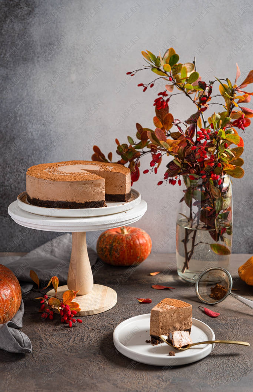 Thanksgiving concept. Chocolate mousse cake on the stand surrounded by autumn lees and pumpkins on