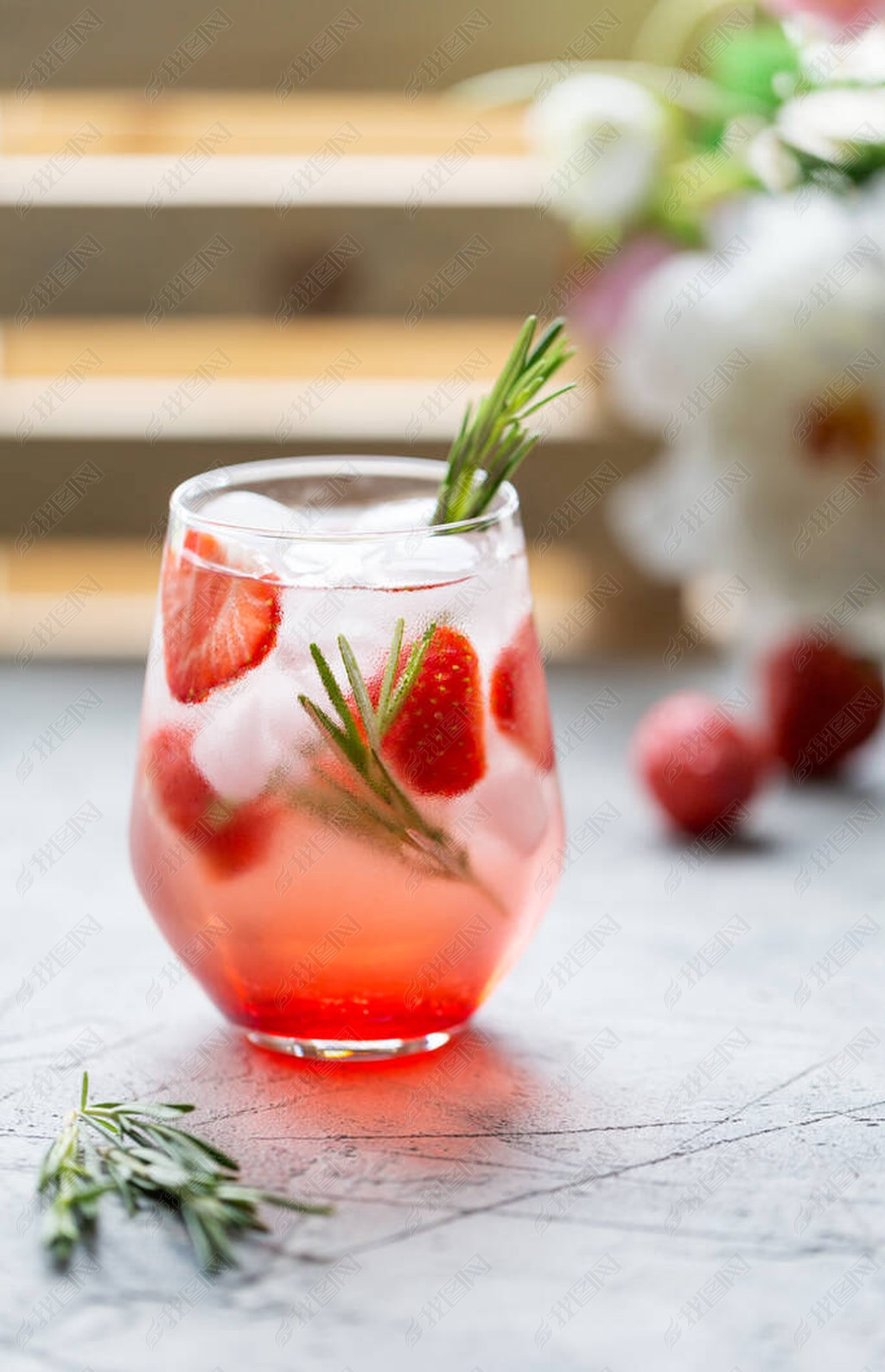 苏打水配草莓和冰块在杯子里冰香草浆果等冷饮的概念鸡尾酒的配方