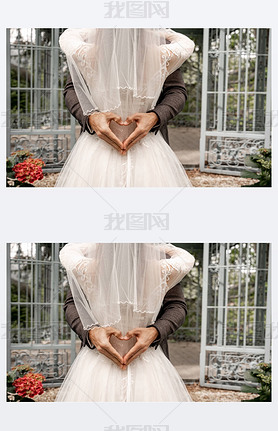 partial view of groom showing heart symbol with hands while embracing bride