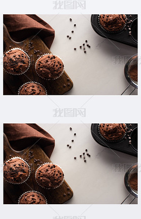 top view of fresh chocolate muffins on wooden cutting board near brown napkin and cocoa powder on ma