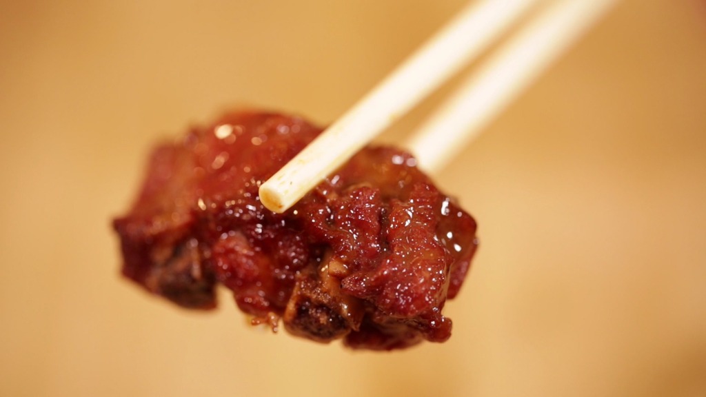 筷子夹起排骨肉