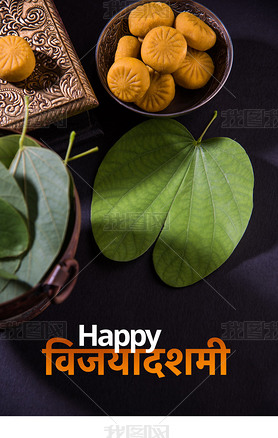贺卡说快乐维贾亚达什米或快乐杜塞赫拉，印度节日杜塞赫拉，显示阿普塔叶或紫荆花与传统的印度糖果佩达在银碗