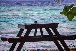 这张独特的照片显示的是一张木桌，它是马尔代夫海滩上一个浪漫的地方