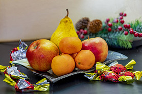 hristmas chocolate fondant individually wrapped in a bowl with fruits and mistletoe. 