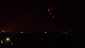 Hot air balloon flying over spectacular Cappadocia under the sky with milky way and shininng star at