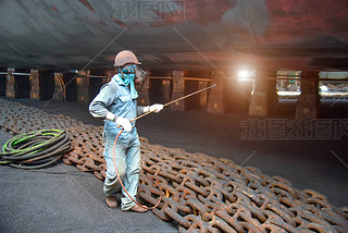 worker, paint man, working for repainting after sand blasting of the bottom layer of the commercial 