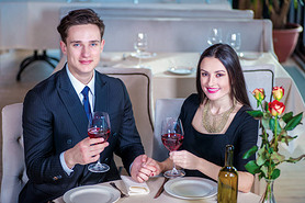 Celebrating a wedding anniversary together. Romantic dinner in the restaurant. Young loving couple v