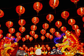 Red lanterns hanging in the black sky and god lamp at night in the Lantern Festival in Thailand.