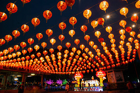 Red lanterns hanging in the black sky and god lamp at night in the Lantern Festival in Thailand.