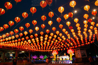 Red lanterns hanging in the black sky and god lamp at night in the Lantern Festival in Thailand.