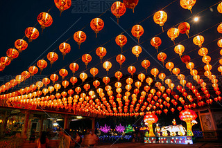 Red lanterns hanging in the black sky and god lamp at night in the Lantern Festival in Thailand.