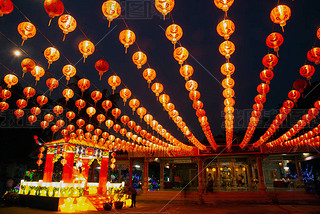 Red lanterns hanging in the black sky and god lamp at night in the Lantern Festival in Thailand.