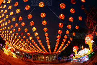 Red lanterns hanging in the black sky and god lamp at night in the Lantern Festival in Thailand.