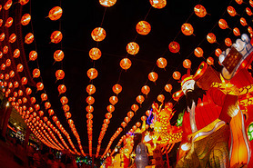 Red lanterns hanging in the black sky and god lamp at night in the Lantern Festival in Thailand.