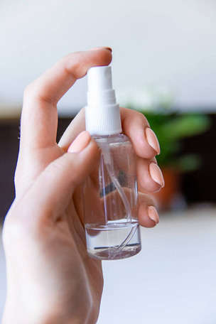 那只手拿着防腐剂,正要按下喷雾器.