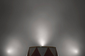 An empty circus ringmasters podium backlit by dramatic spot lights on a dark moody background - 3D r