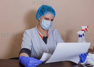 A female doctor in a sterile mask and uniform on a break after prevention during the covid-19 corona