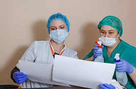 A female doctor in a sterile mask and uniform on a break after prevention during the covid-19 corona