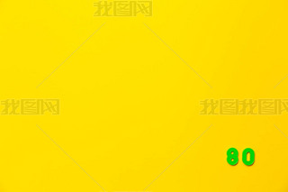 A green plastic toy number 80 is located in the lower right corner on a yellow background.