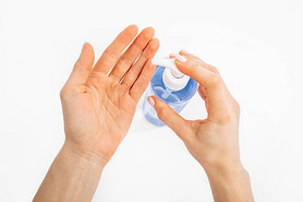 Disinfection of hands. Man applying antiseptic spray to his hands to prevent coronavirus or flu, on 