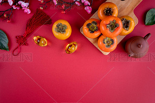 Top view of fresh sweet persimmons kaki with leaves on red table background for Chinese lunar new ye