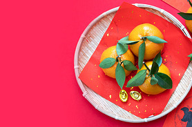 tangerines and Chinese coins on a red background. Prosperity concept 