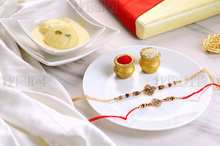 ӡRaksha BandhanڣRakhi  Sweets  Rice Grains  KumkumGift ΪֵܽüİףĴͳ.