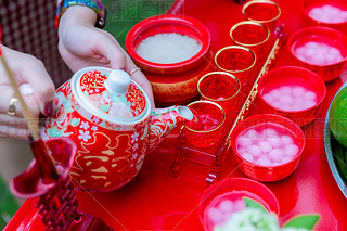 传统的中国茶具在结婚日举行。在中国婚礼上倒茶。照片中的中文文字读作双喜，翻译快乐，快乐倍增. 