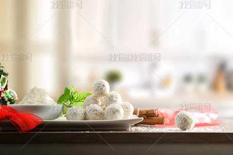 厨房餐桌，用椰子和白色厨房背景的碗为活动准备椰子球。1.横向构成.