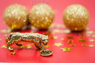 A bronze figure of a tiger with a coin - the symbol of the Chinese new year 2022 on a red background